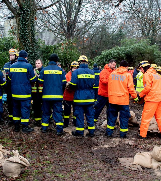 Einsatzkräfte des Technischen Hilfswerks (THW) sind im Einsatz, um ein Wohnhaus am Osternburger Kanal vor dem drohenden Hochwasser mit Sandsäcken zu sichern.