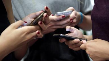 Eine Gruppe Teenager mit ihren Smartphones