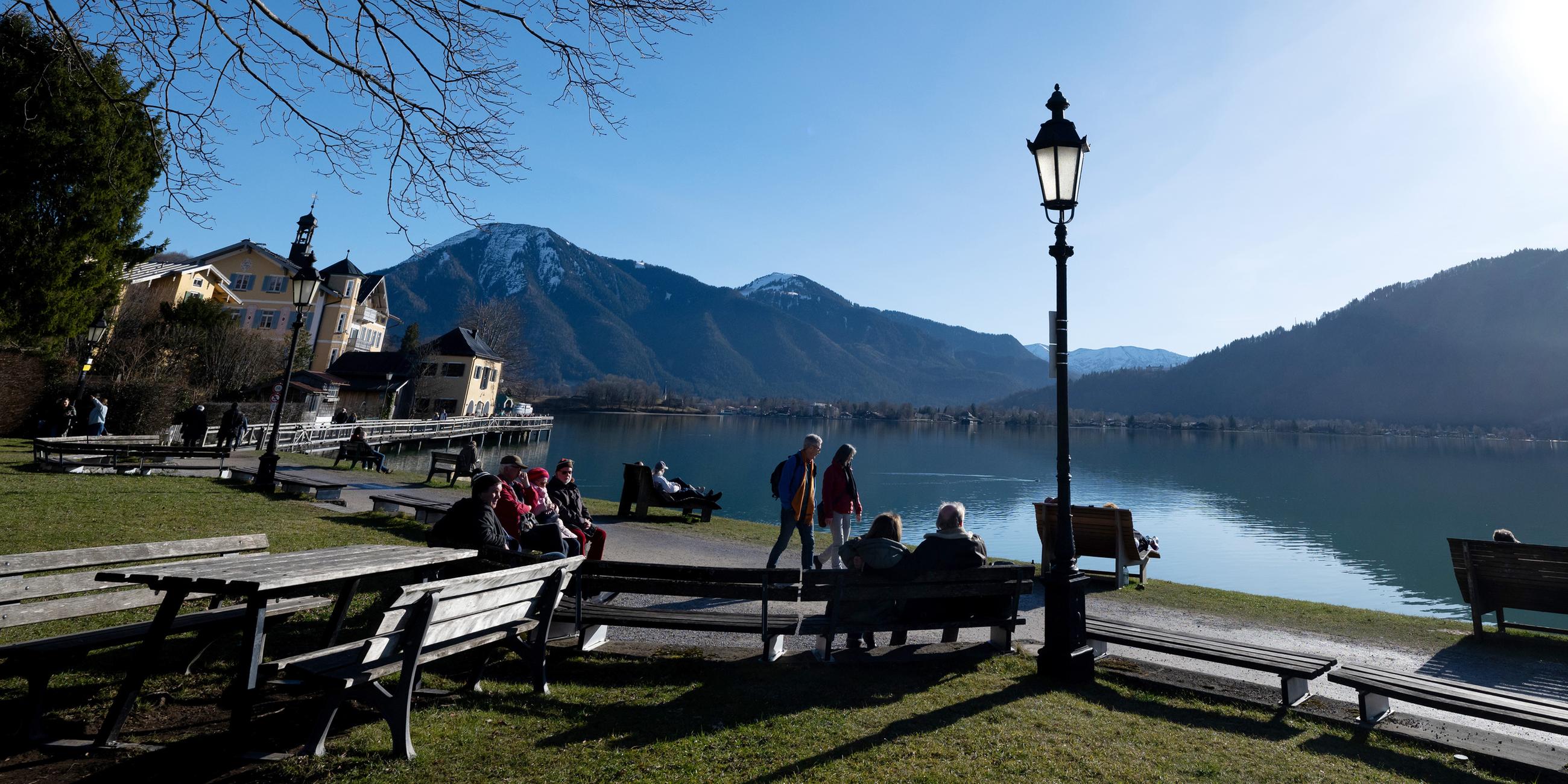 Archiv: Ausflügler genießen auf Bänken das schöne Wetter am Ufer des Tegernsees