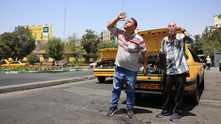 Zwei Taxifahrer erfrischen sich während einer Hitzewelle in der iranischen Hauptstadt. 