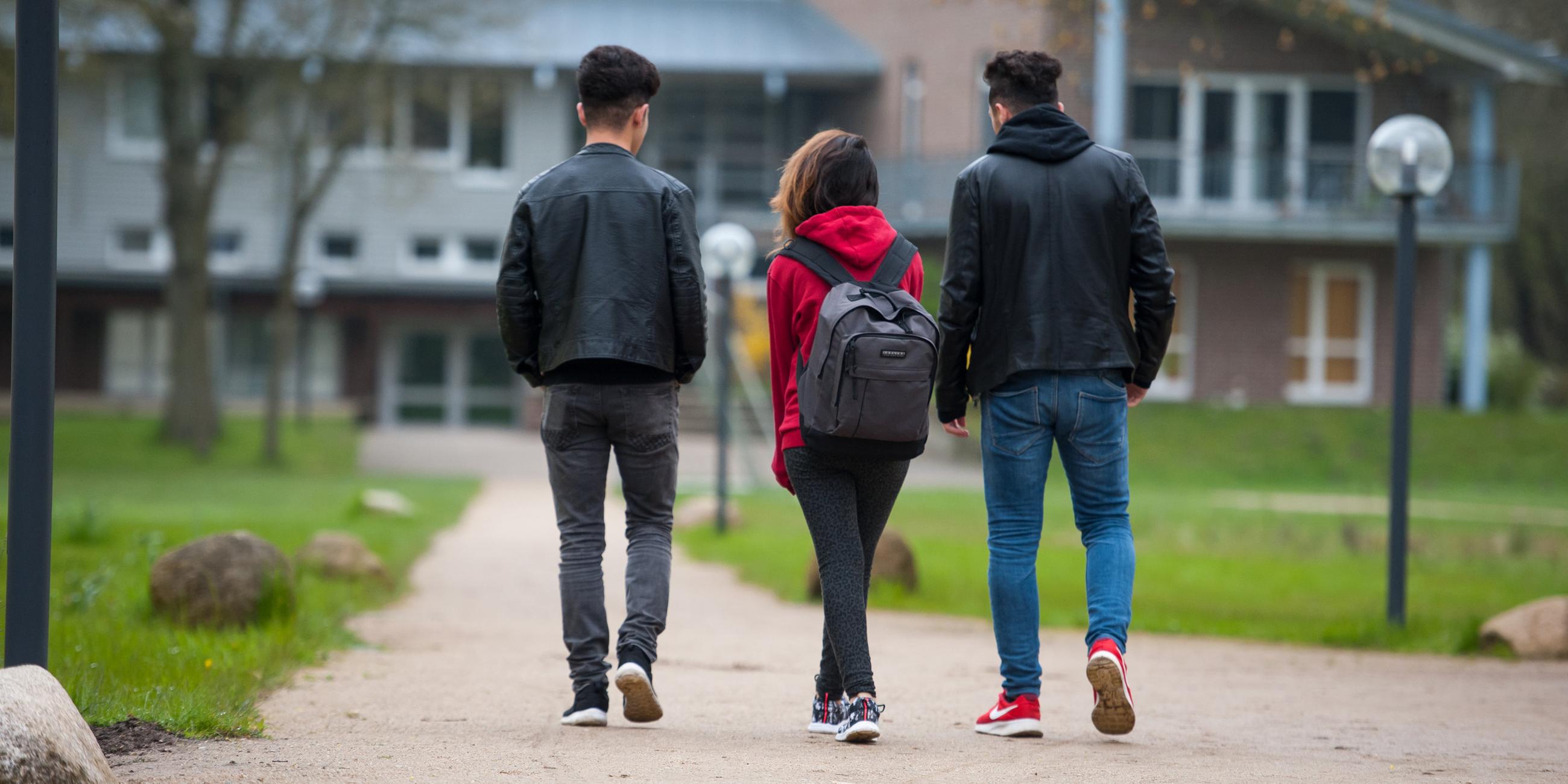Drei jugendlichen syrische Flüchtlinge gehen am 27.04.2016 in Dahlem bei Dahlenburg (Niedersachsen) auf dem Gelände des Internatsgymnasium Marienau zum Unterricht