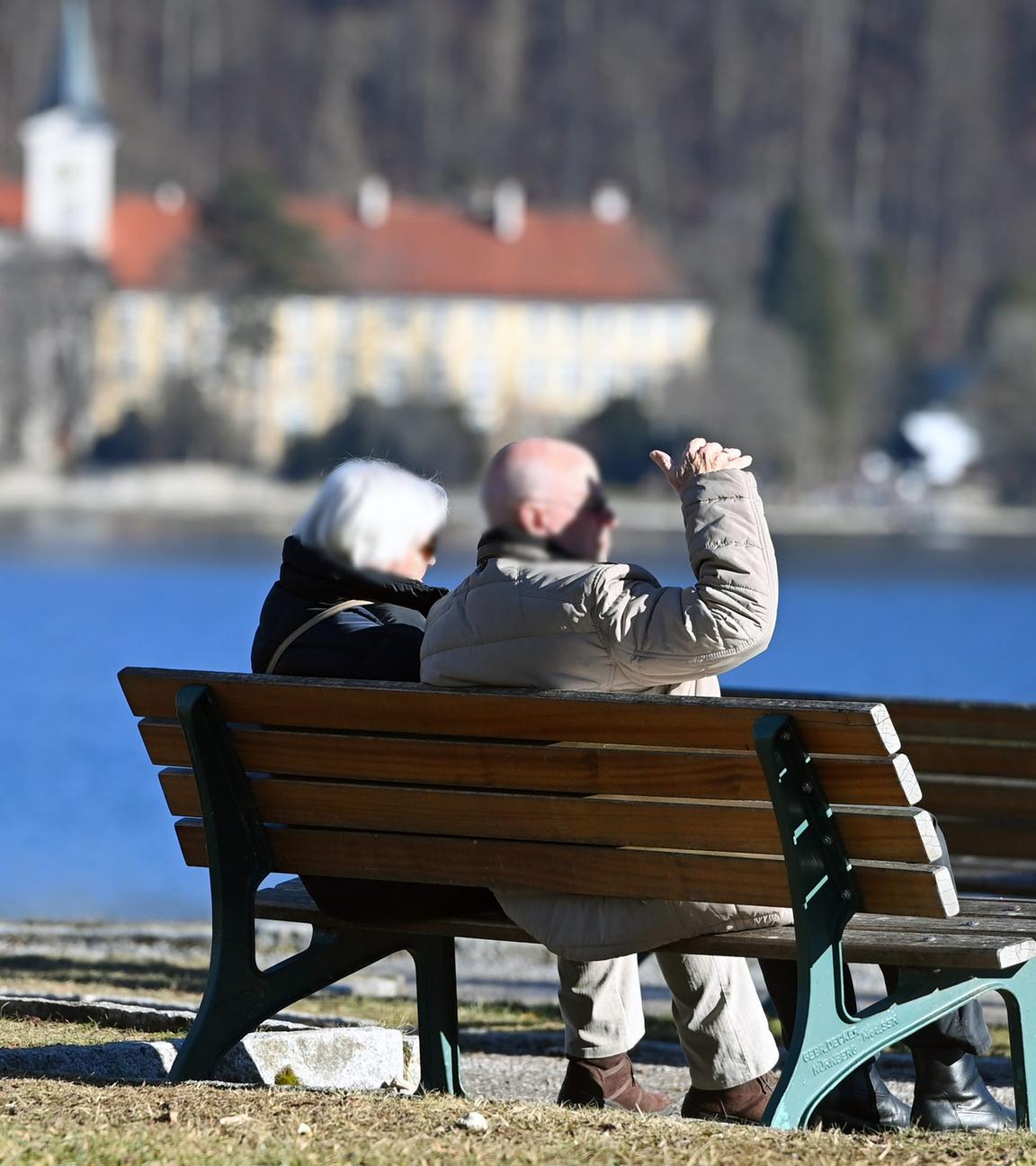  Ehepaar-Rentner -Mann und Frau sitzen auf einer Bank am Ufer des Tegernsees