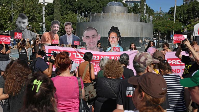 People lift placards and portraits of Israelis held hostage in the Gaza Strip since 2023, during a rally in Tel Aviv marking the second anniversary of the attacks by Palestinian militants, on October 7, 2025.