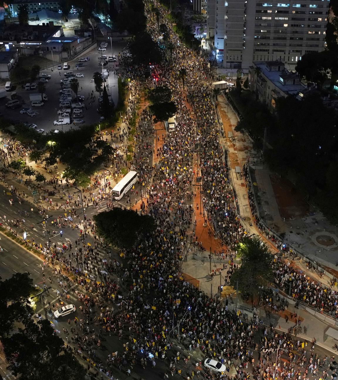 Eine Luftaufnahme bei Nacht der Straßen von Tel Aviv, die mit Tausenden Demonstranten gefüllt sind.