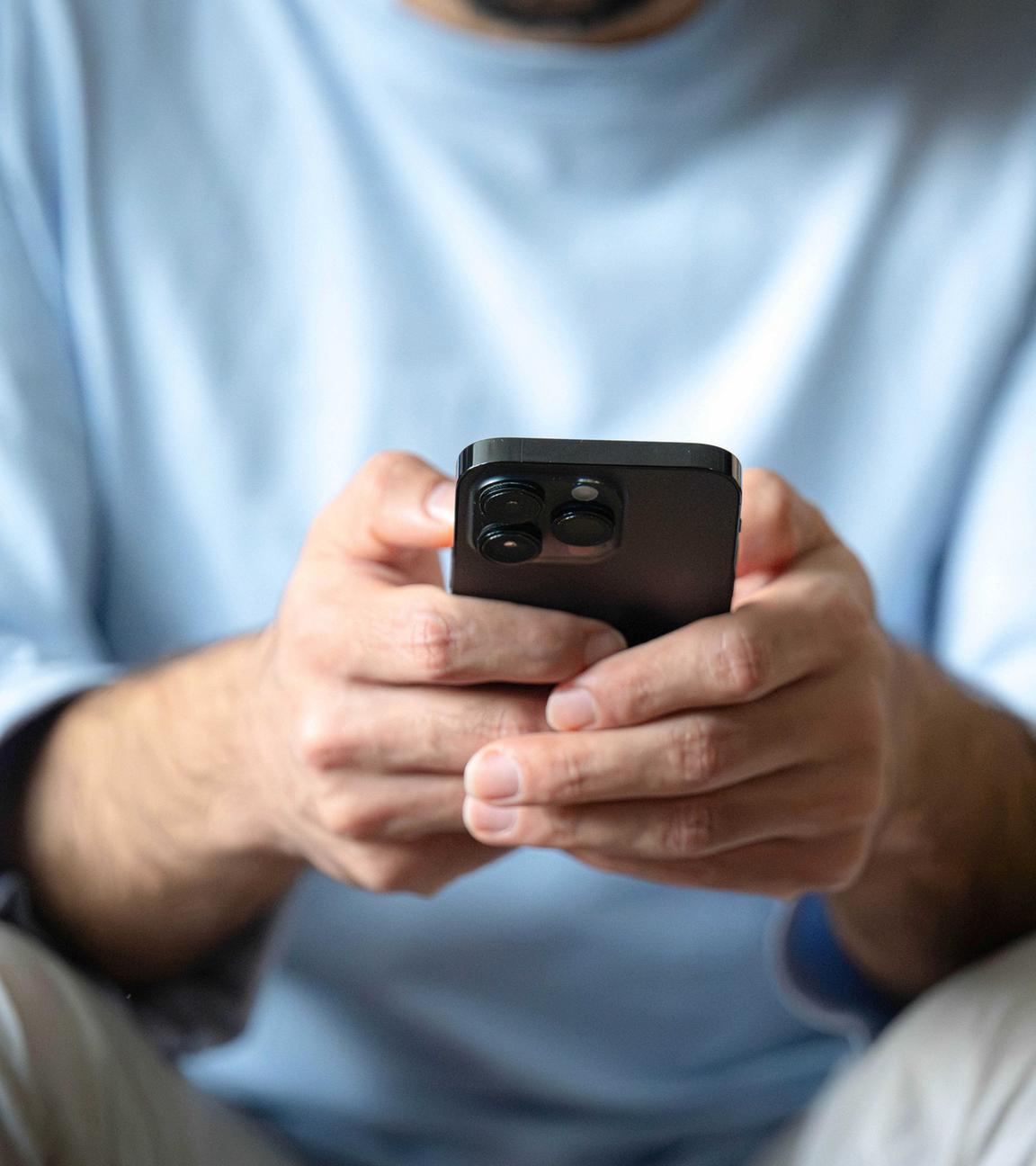 Ein Mann tippt auf einem Smartphone.