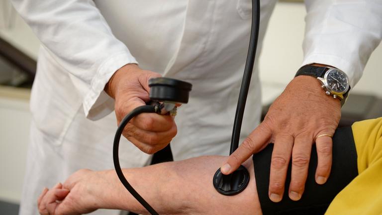 Arzt misst Blutdruck einer Patientin. Archivbild