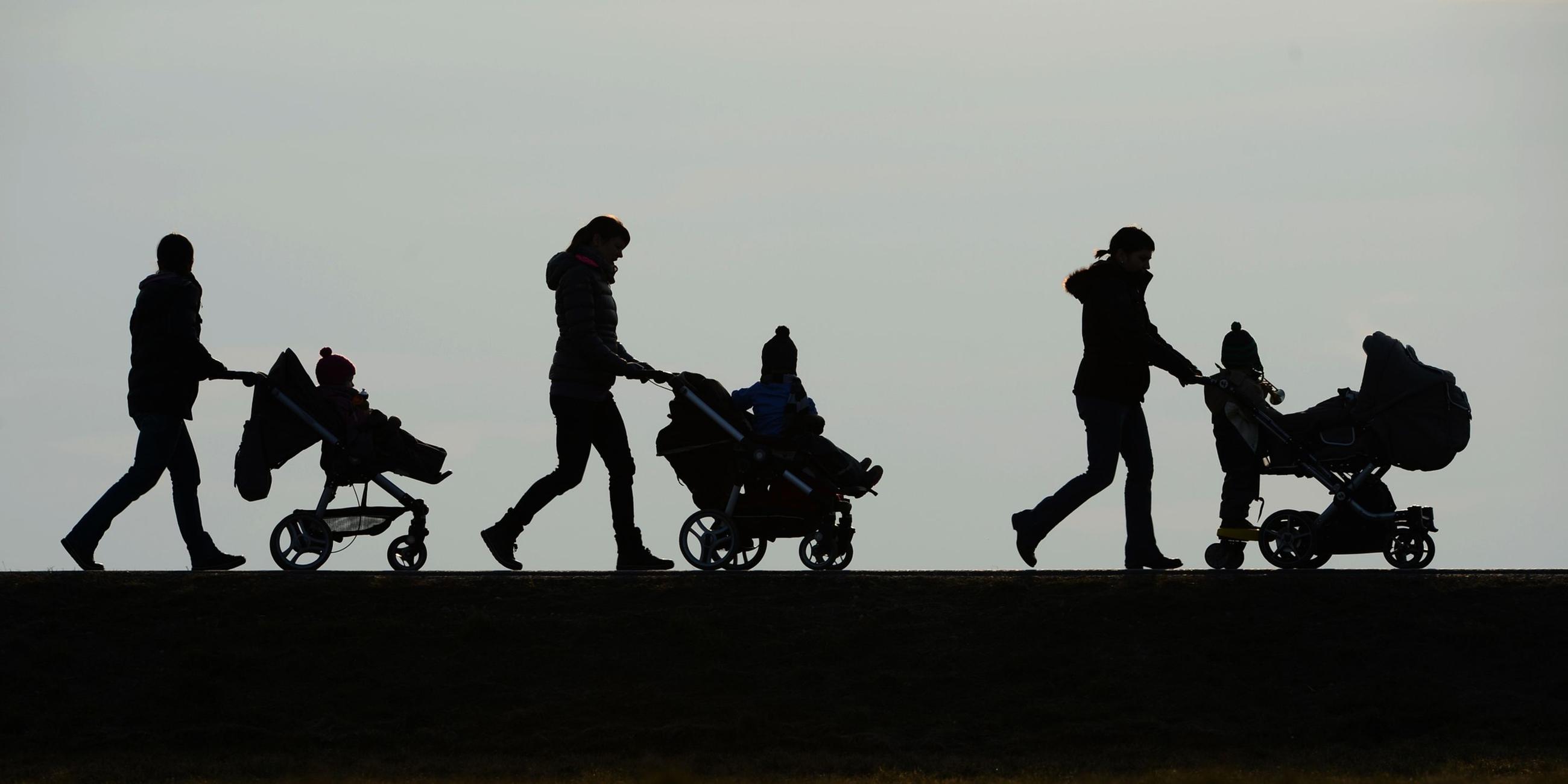 s/w Drei Mütter schieben Kinderwagen.