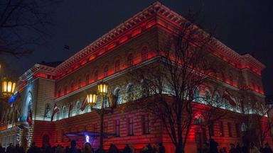 Das in Nationalfarben angestrahlte lettische Parlament.