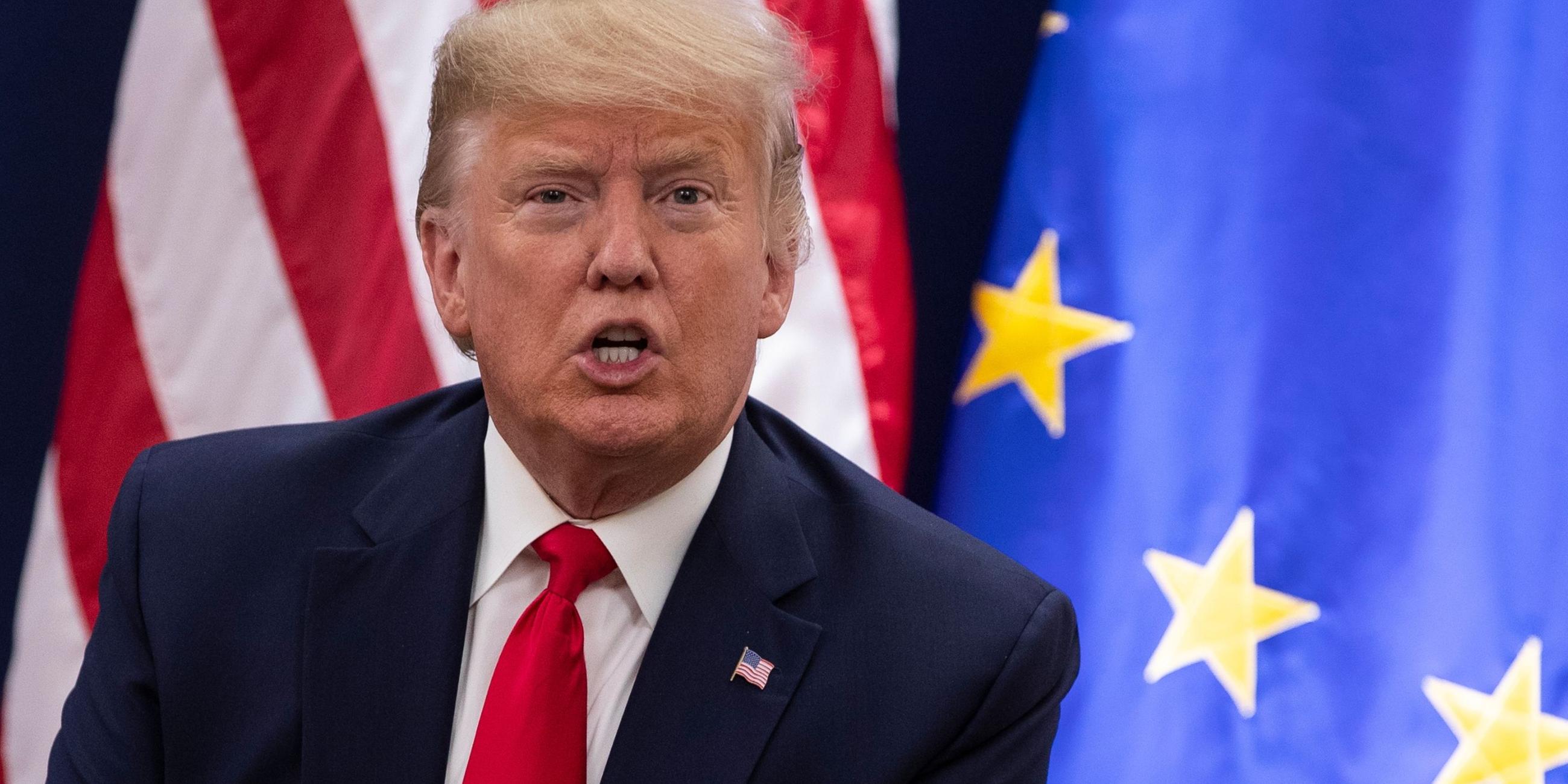 Donald Trump vor Flaggen der USA und der EU. Archivbild