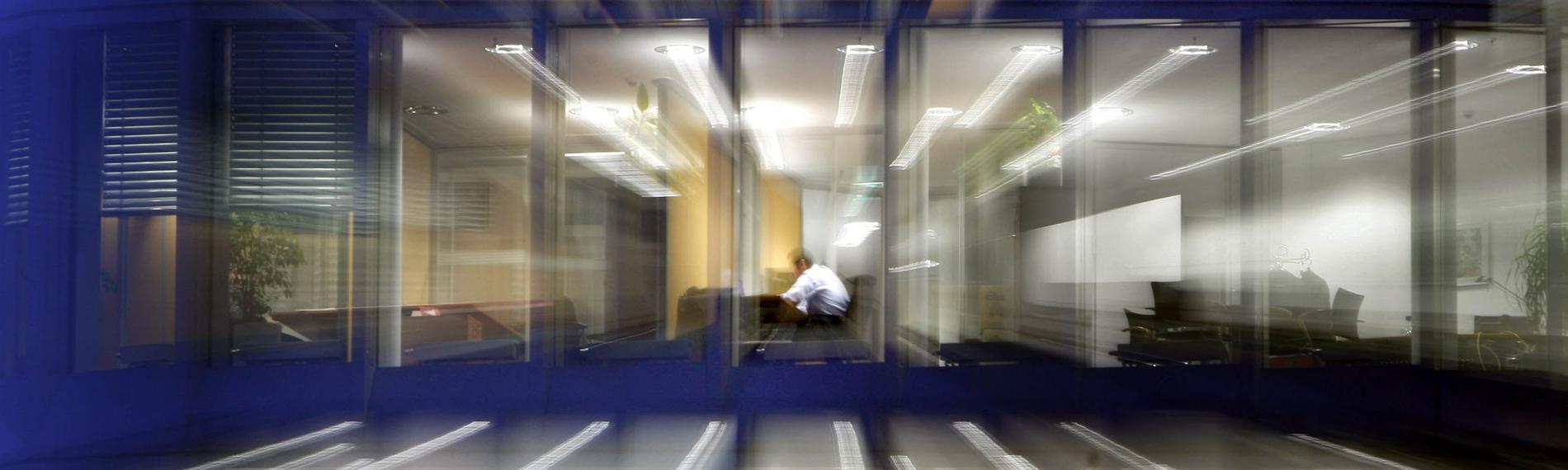 Ein Angestellter sitzt am Abend in seinem Büro. Symbolbild