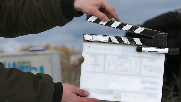 Ein Film-Team-Mitarbeiter hält eine Filmklappe. Archivbild