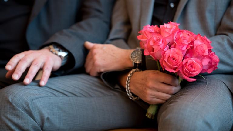 Ein Mann hält bei der Eheschließung einen Blumenstrauß. Archiv