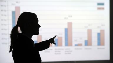 Eine Frau erklärt eine Grafik. Symbolbild