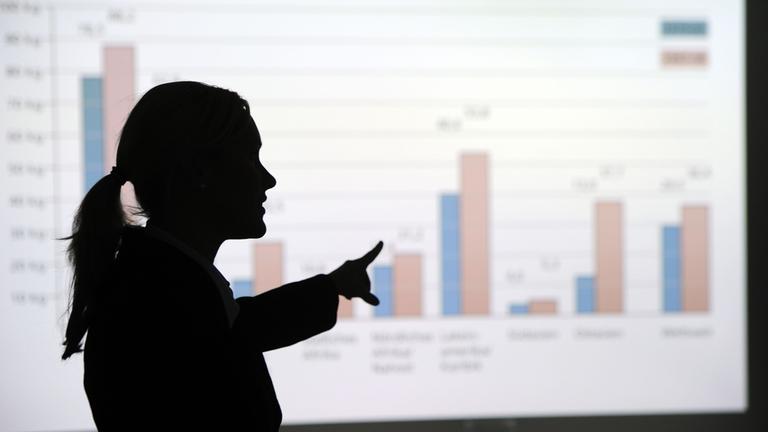 Eine Frau erklärt eine Grafik. Symbolbild