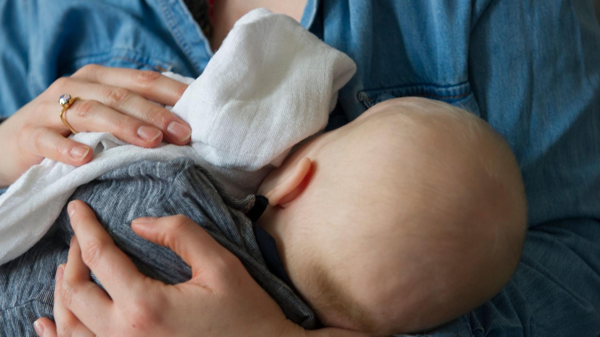 Eine Frau hält ihr Baby im Arm.