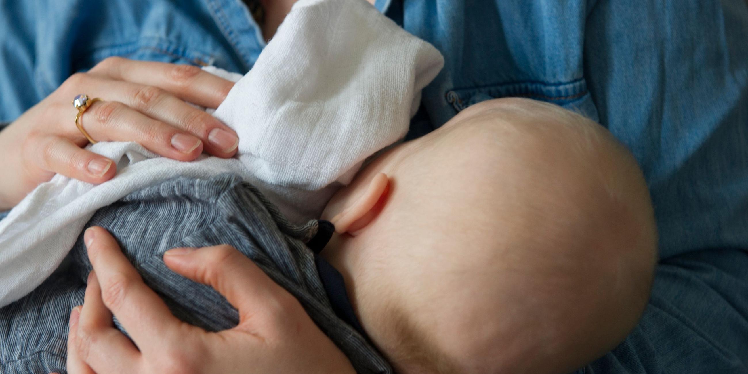 Eine Frau hält ihr Baby im Arm.