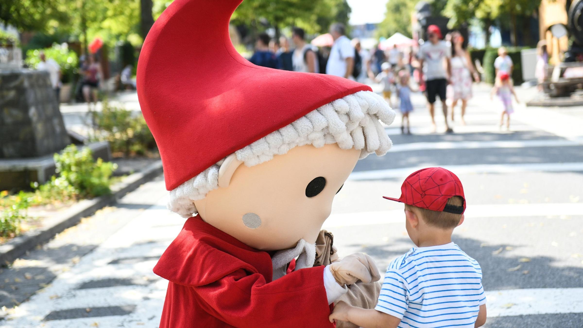 Ein Sandmännchen begrüßt einen Jungen bei dem Geburtstagsfest.