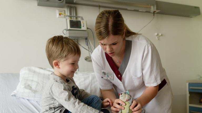 Kinderkrankenschwester mit jungem Patienten.