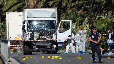 Polizisten stehen um den beim Anschlag benutzten Lkw.