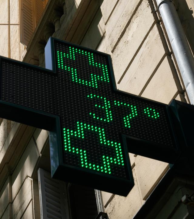 Auf einem Schild vor einer Pariser Apotheke wird eine Temperatur von 37 Grad Celsius am 21.06.2026 in Paris angezeigt.