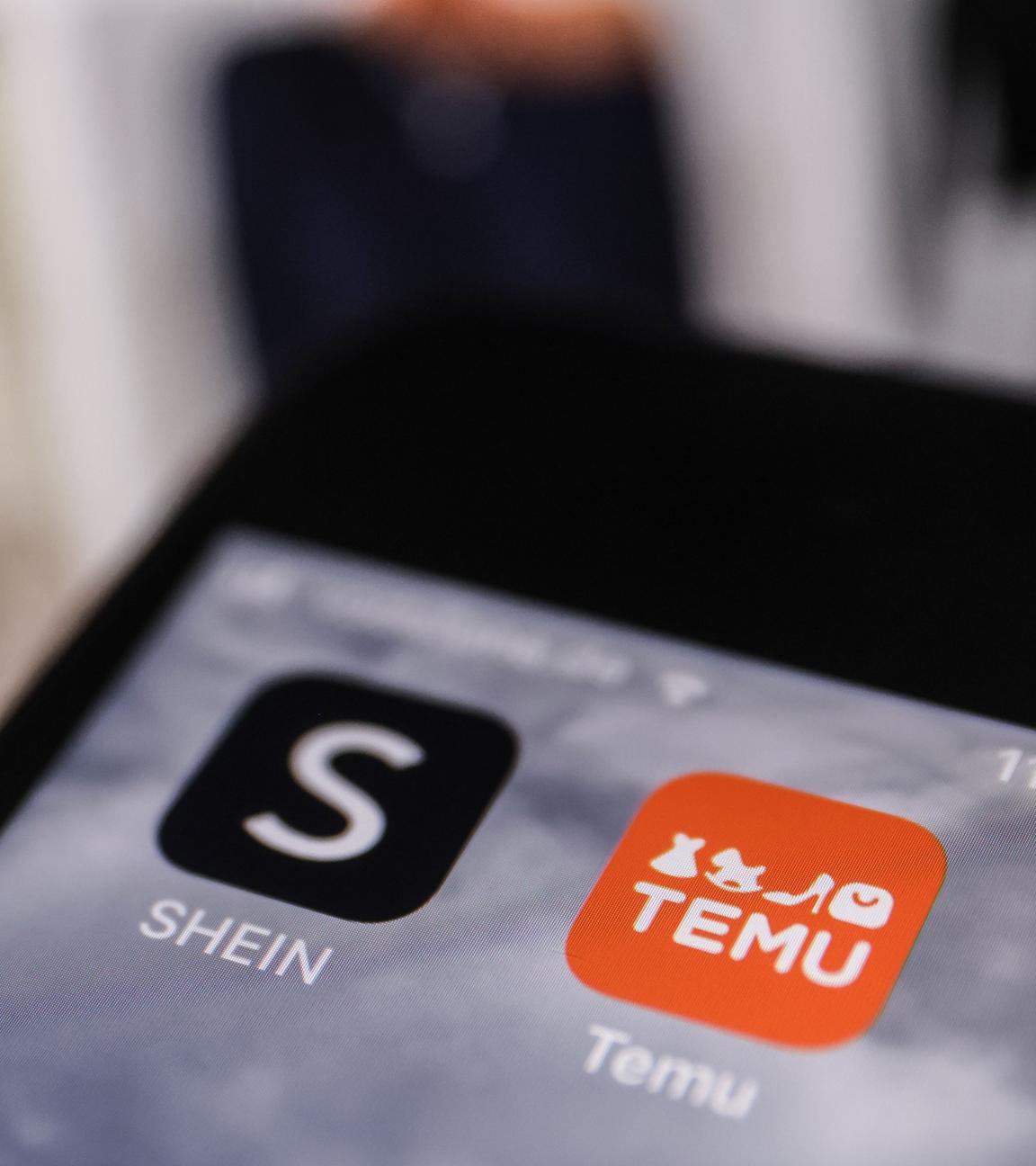 Die Apps der Internethändler Temu und Shein sind auf dem Display eines Smartphones zu sehen. 