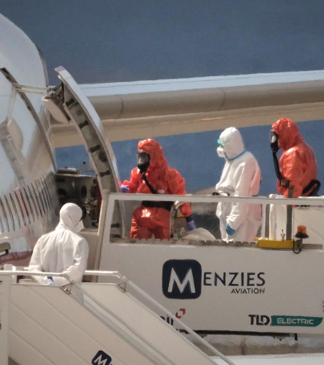 Ein Passagier in weißer Schutzkleidung besteigt auf dem Flughafen von Teneriffa ein spanisches Regierungsflugzeug, nachdem er das vom Hantavirus befallene Kreuzfahrtschiff MV Hondius verlassen hat.