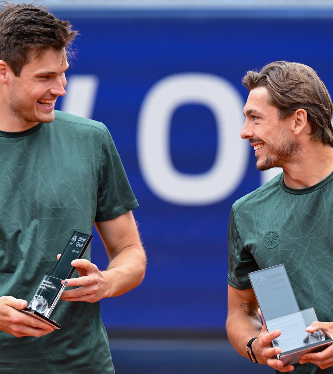 Jakob Schnaitter (r, Deutschland) und Mark Wallner (Deutschland) jubeln am 19.04.2026 in München nach dem Spiel mit dem Pokal.