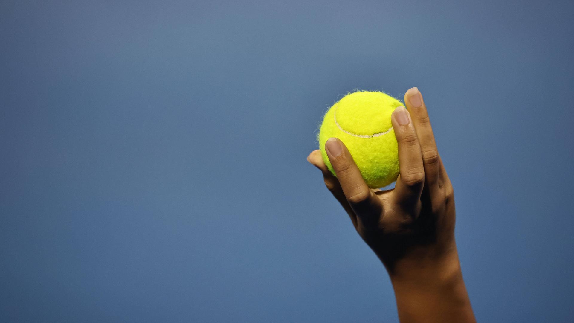 Frauenhand mit Tennisball