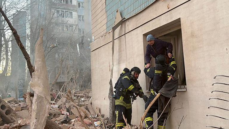 Ein von der Nationalpolizei der Ukraine über Telegram zur Verfügung gestelltes Foto zeigt ukrainische Rettungskräfte, die einem Mann am Ort eines russischen Angriffs helfen. 