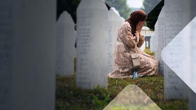Eine Frau an einem Grab der Gedenkstätte Srebrenica