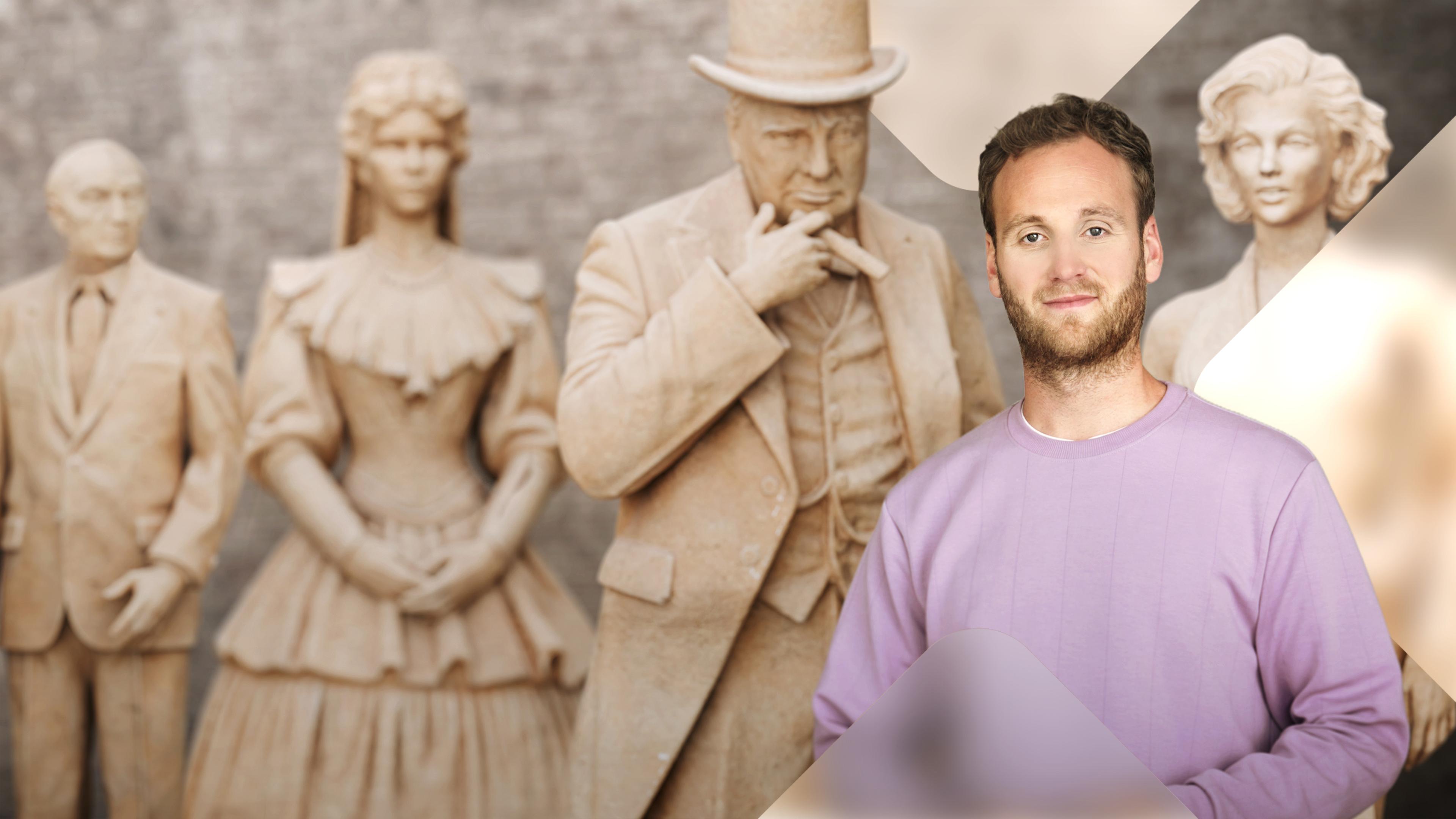 Moderator Leon Windscheid auf der rechten Seite. Hinter ihm gestaffelt Statuen von berühmten Personen. Winston Churchill, Sissi, Konrad Adenauer und Marilyn Monroe. 