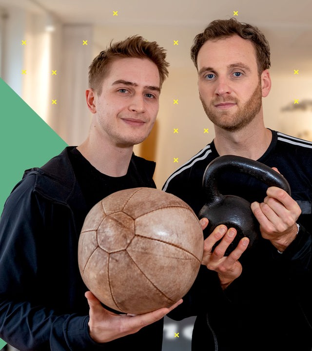 Biohacker Maurice Lichtenberg hat einen Ball in der Hand, daneben steht Psychologe Leon Windscheid mit einem Gewicht in den Händen