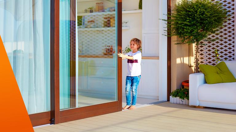 Kind schließt eine Terrassentür