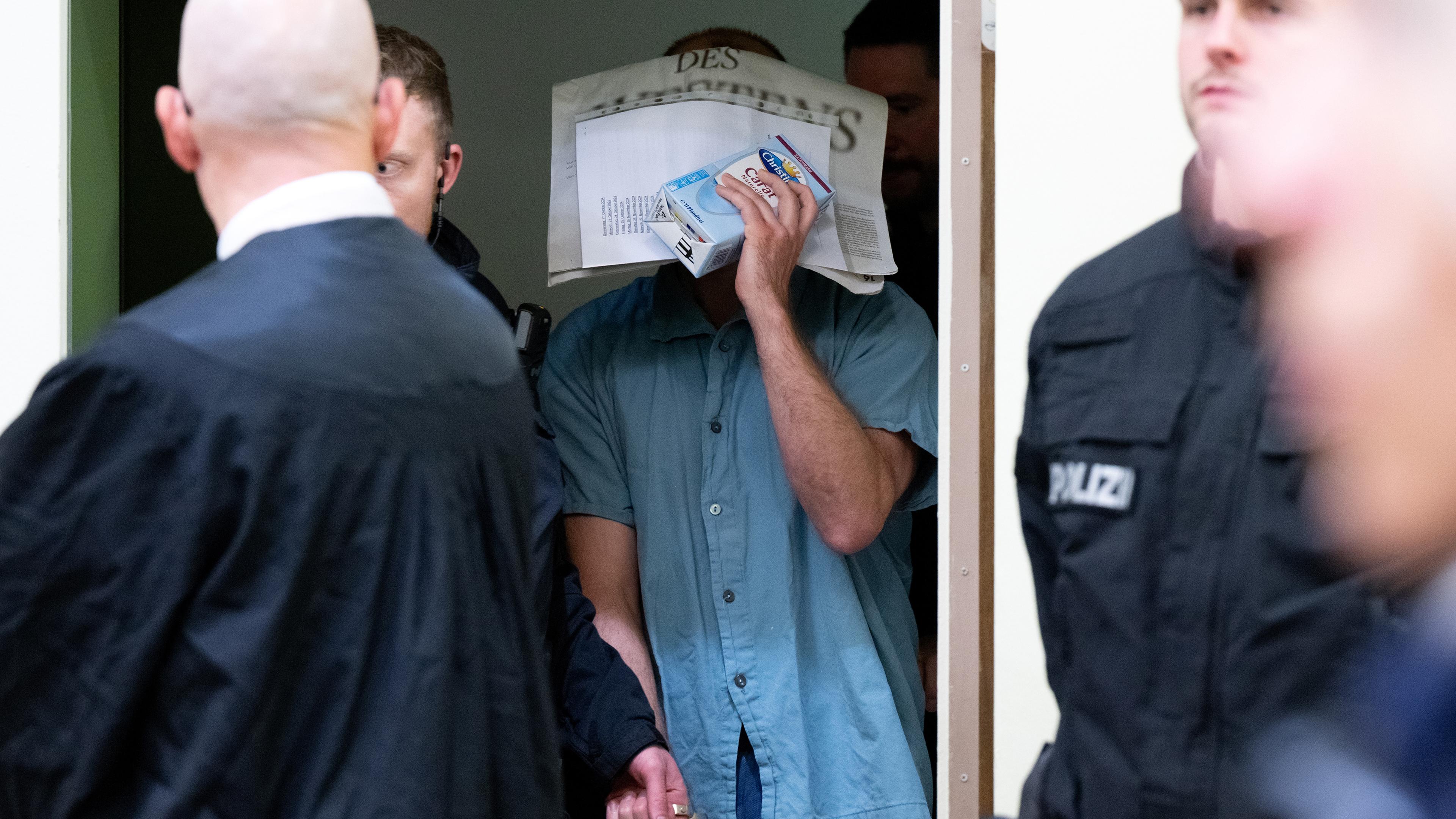 Ein wegen Mitgliedschaft in einer terroristischen Vereinigung und die Vorbereitung eines sogenannten hochverräterischen Unternehmens angeklagter Mann wird im Oberlandesgericht in den Gerichtssaal geführt.