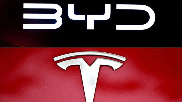 Eine Collage des BYD und Tesla-Logos. Oben auf Schwarzem Grund mit weißer Schrift das BYD-Logo, unten das weiße Tesla-Logo auf rotem Grund.