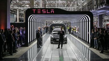 Tesla-CEO Elon Musk (M.) hält neben Brandenburgs Ministerpräsident Dietmar Woidke (2. v. l.) und Bundeskanzler Olaf Scholz (l.) am Eröffnungstag der Tesla-Gigafactory in Grünheide bei Berlin, Deutschland, am 22. März 2022 eine Rede.