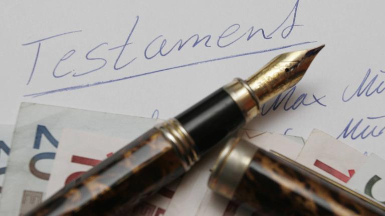 Geldscheine und Füller auf handgeschriebenem Testament