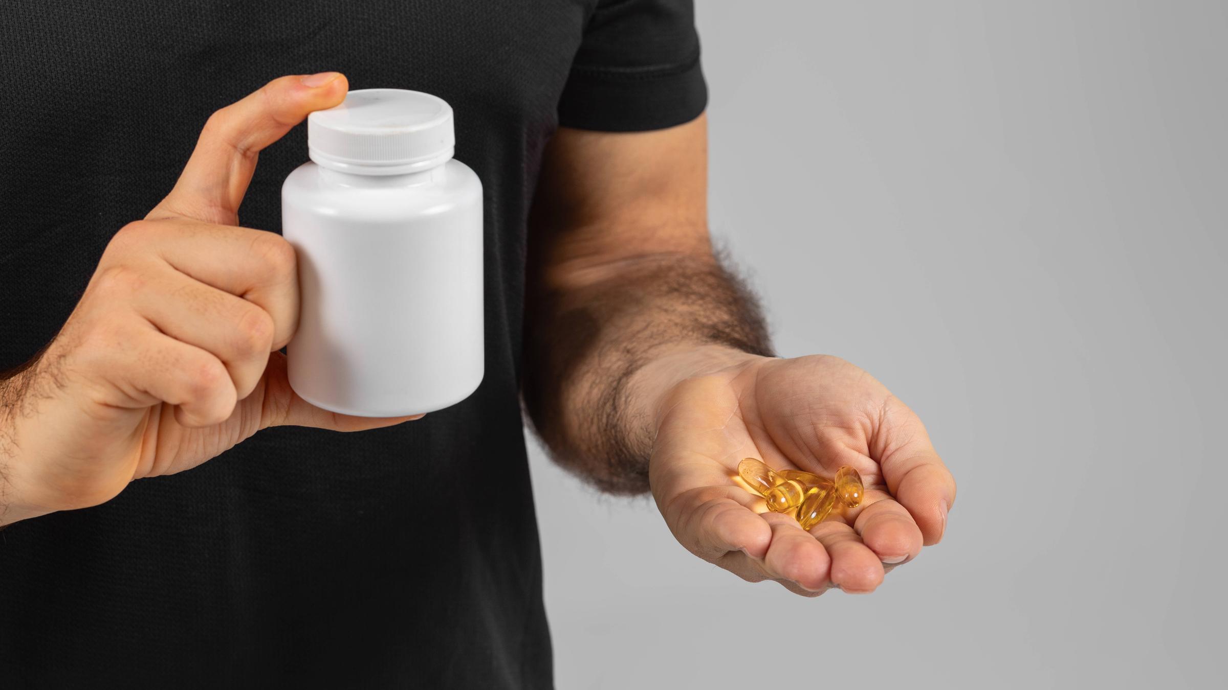 Mann mit Nahrungsergänzungsmittel in Kapselform
