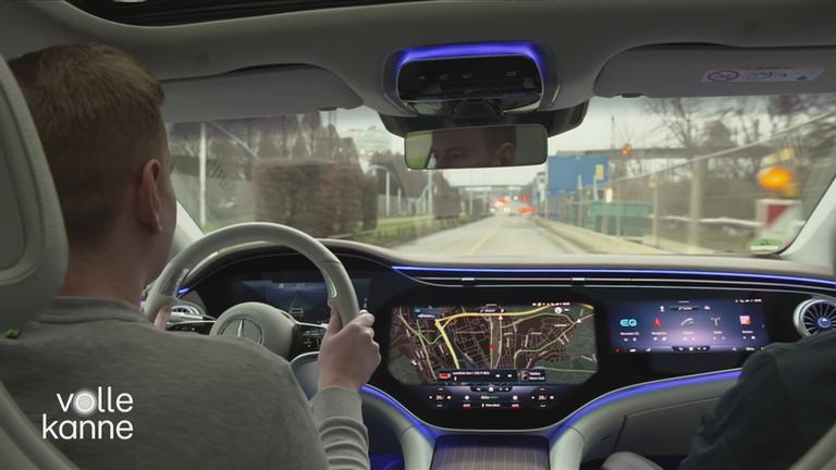 Mann hinter Lenkrad und sehr modernem Display