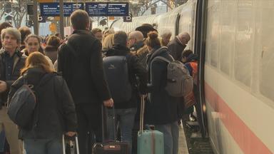 Voller Bahnsteig vor Zug