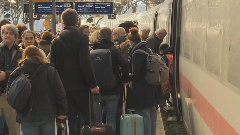 Voller Bahnsteig vor Zug