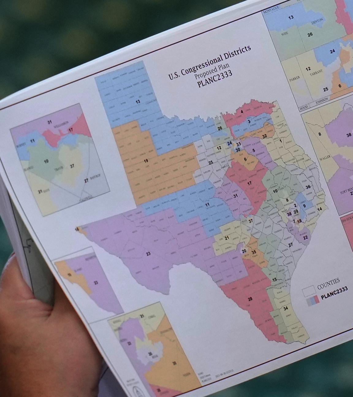 Ein Senator in Texas hält eine Karte mit den neuen Wahlbezirken in der Hand.