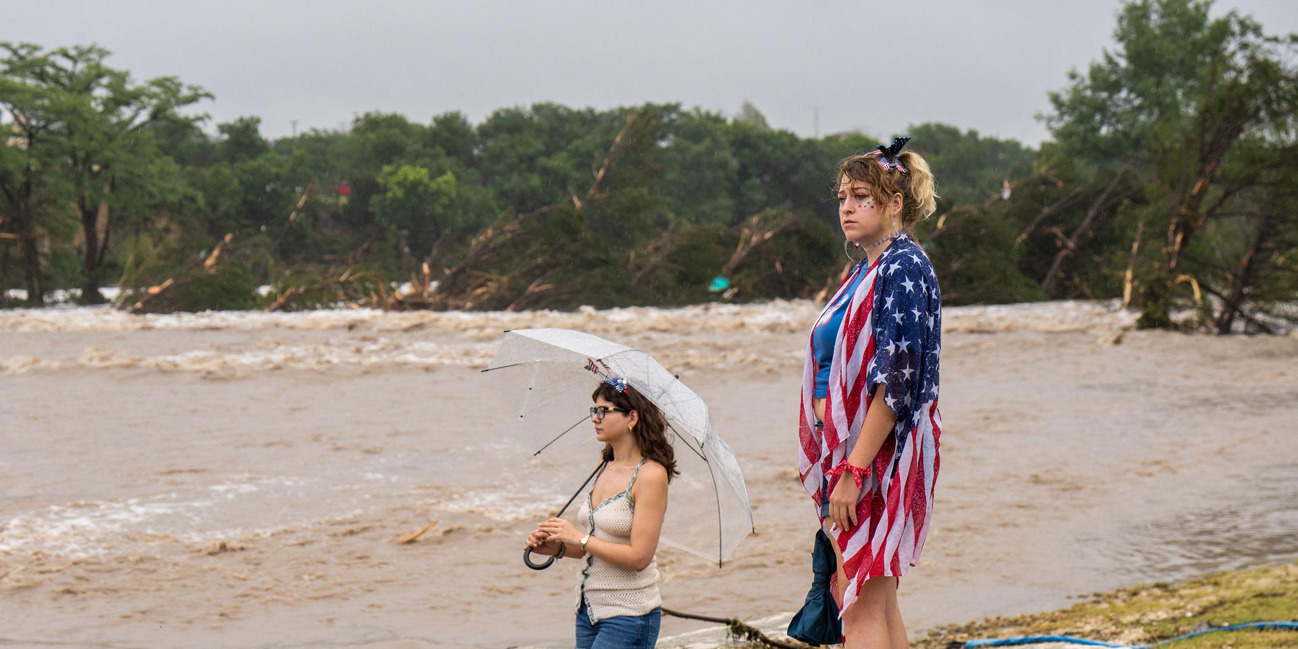Passanten stehen am Ufer des Guadalupe River nach einem Unwetter in Kerrville, Texas. Aufgenommen am 04.07.2025