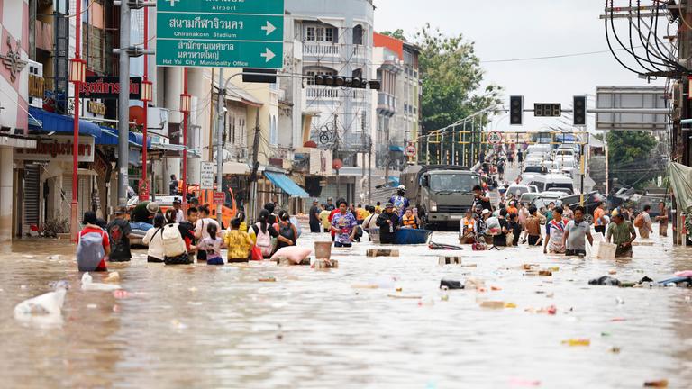 Thailand, Songkhla: Menschen waten durch das Hochwasser in der Provinz Songkhla im Süden Thailands.