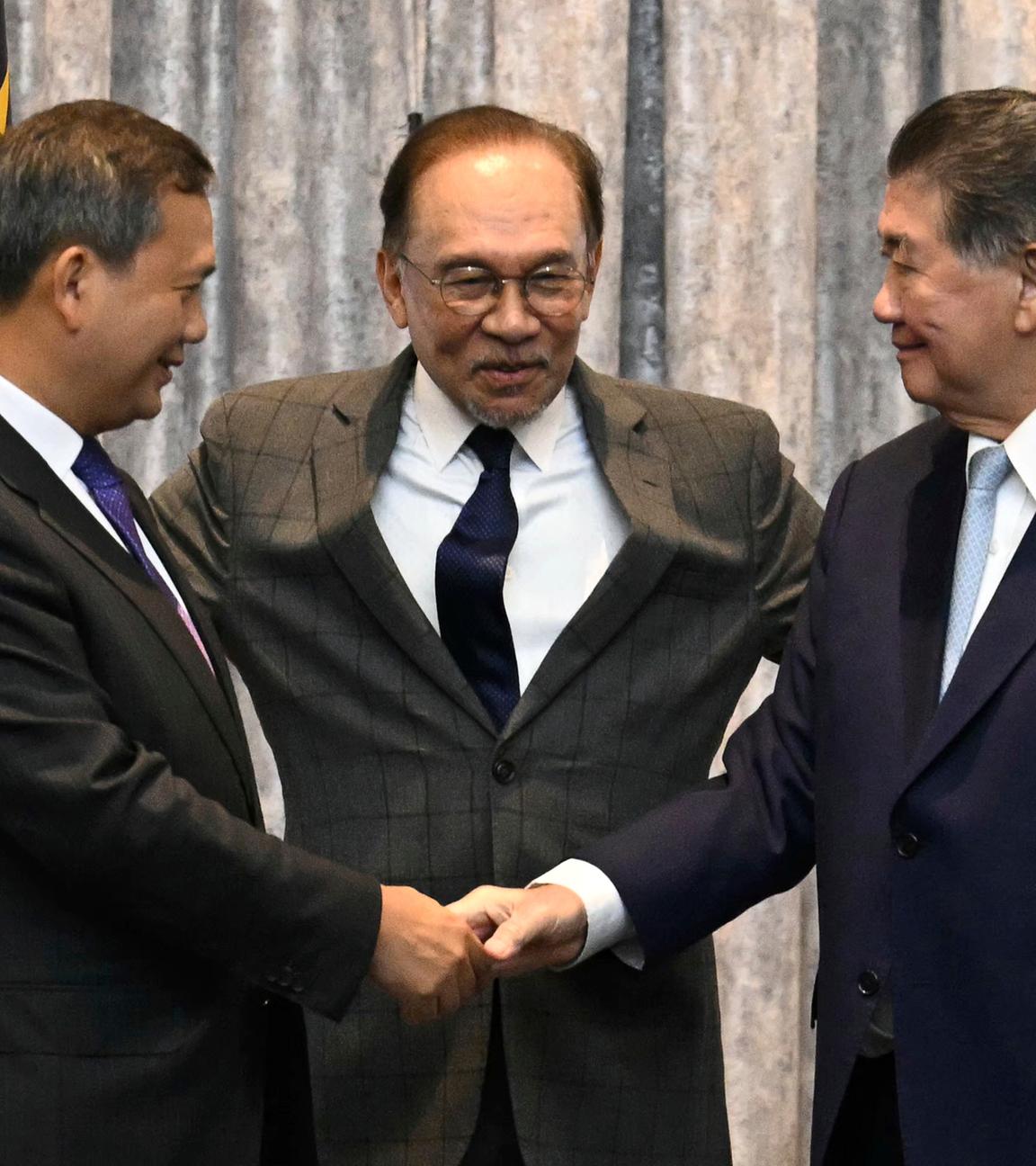 Der kambodschanische Premierminister Hun Manet (l) und der amtierende thailändische Premierminister Phumtham Wechayachai (r) reichen sich die Hände, während der malaysische Premierminister Anwar Ibrahim nach Gesprächen über einen möglichen Waffenstillstand zwischen Thailand und Kambodscha gestikuliert