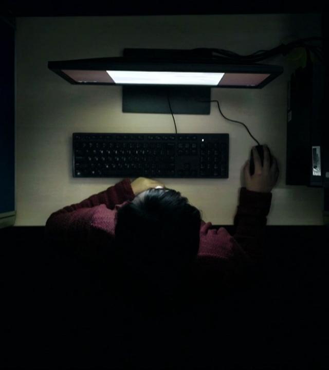 Mann sitzt im Dunkeln vor PC