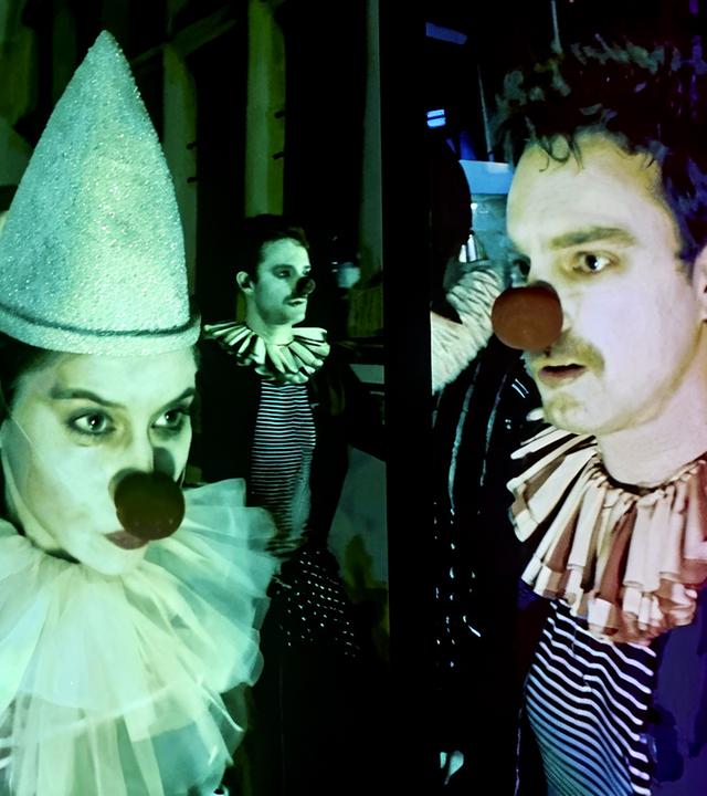 Eine Frau und ein Mann haben sich als Harlekin und Clown verkleidet.