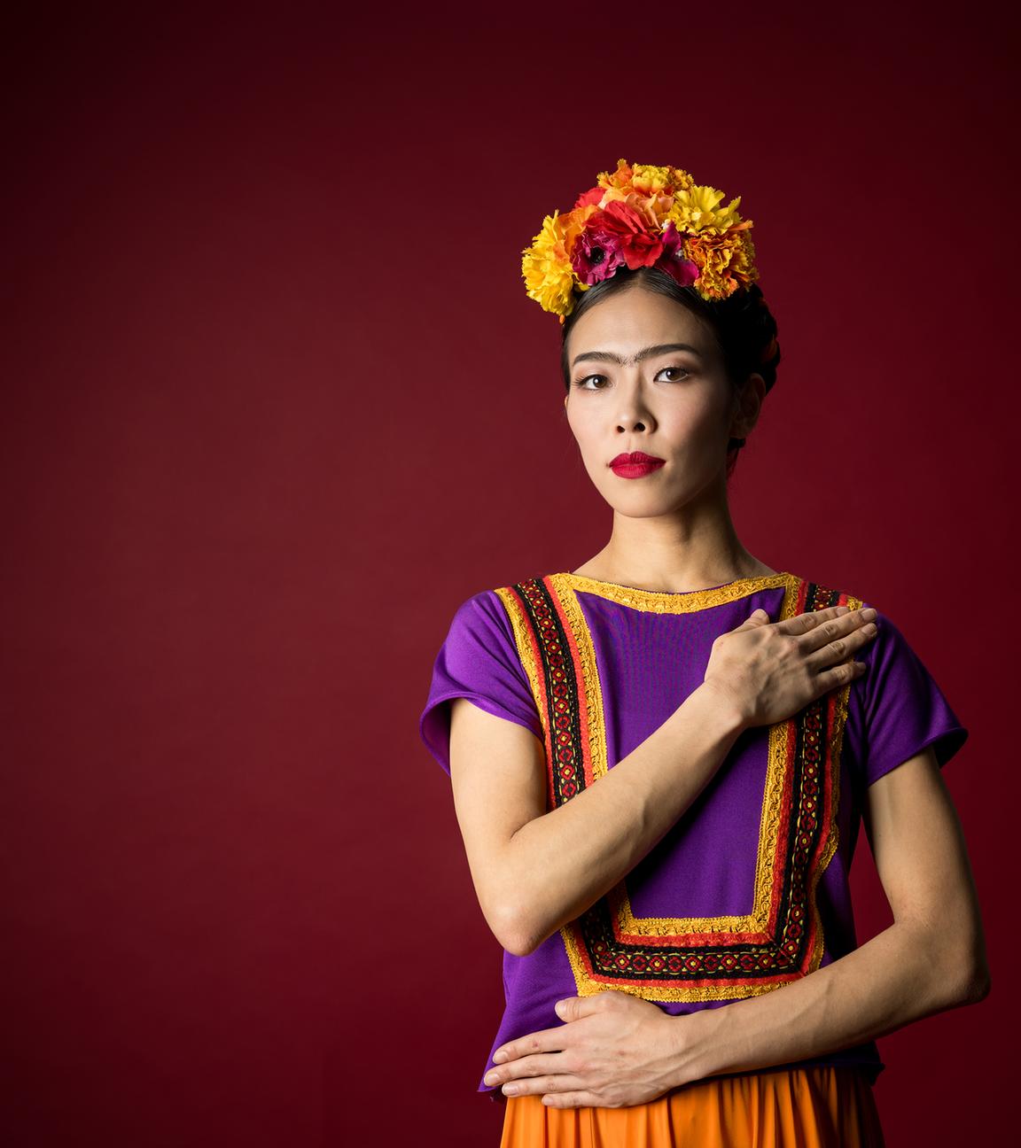 Man sieht eine Frau in folkloristisch, bunter Bekleidung.