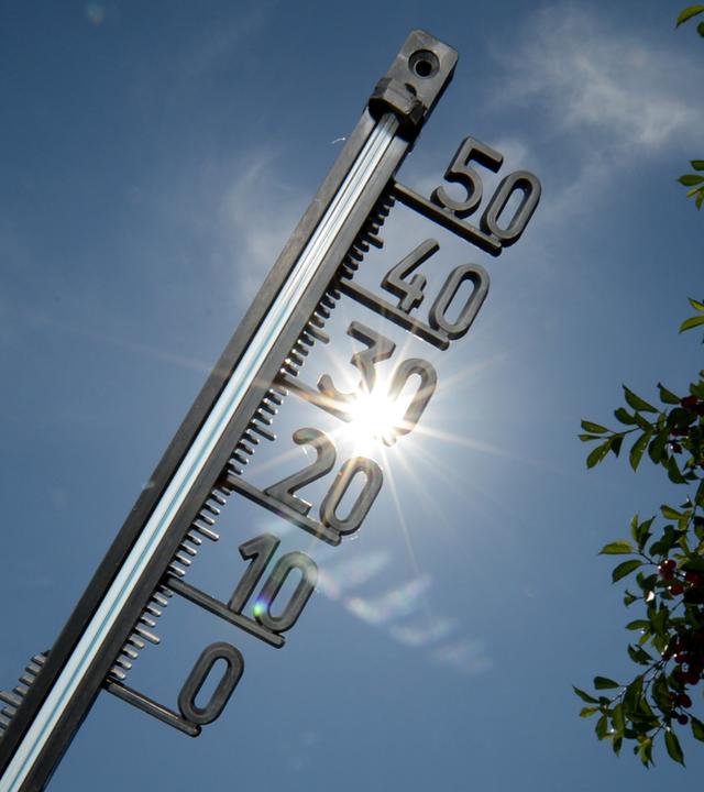 Thermometer vor sonnigem Himmel