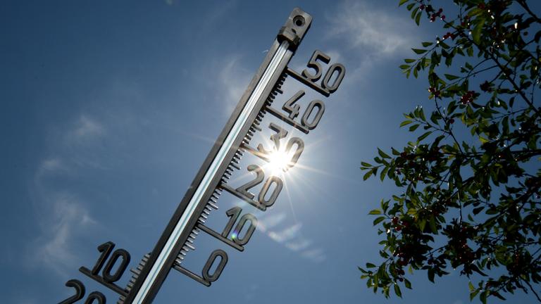 Thermometer vor sonnigem Himmel